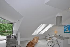 um quarto branco com uma mesa e cadeiras e uma janela em Sandhalm em Heikendorf
