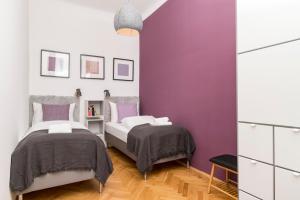 two beds in a bedroom with purple walls at Business Suite St Marx in Vienna