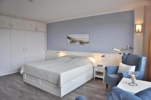 une chambre d'hôtel avec un lit et une chaise dans l'établissement Kapitaen Haddock, à Brasilien