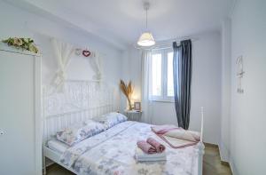 a bedroom with a white bed with pink shoes on it at Dida moj in Senj