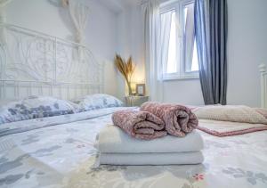 a white bedroom with a bed with a large headboard at Dida moj in Senj