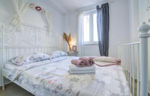 a bedroom with a white bed with a white crib at Dida moj in Senj