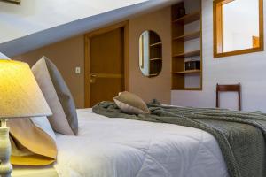 1 dormitorio con cama blanca y manta en La Plage - Home and Sea, en Nizza di Sicilia