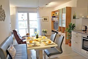 een keuken en eetkamer met een tafel en stoelen bij Sommerbrise Wallbox in Laboe