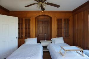a bedroom with two beds and a ceiling fan at The Royal Oak in Cranston