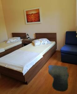 um quarto com 2 camas e uma cadeira azul em Apartments Marijana em Vodice