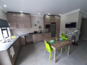 cocina con mesa de madera y sillas verdes en Studio 4 The Studios at Churchill, en Hillcrest