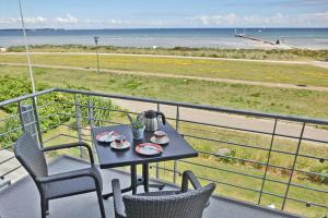 a table and chairs on a balcony with a view of the ocean at Seeadler in Stein