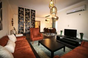 sala de estar con sofá, sillas y TV en Elegant home in Madinaty compound, en El Cairo