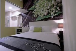 um quarto com uma cama com uma pintura de flores na parede em J8 Hotel em Singapura