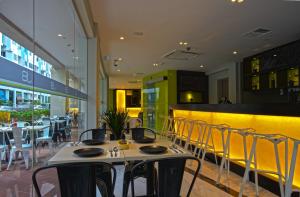 uma sala de jantar com mesas e cadeiras num restaurante em J8 Hotel em Singapura