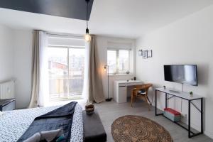 1 dormitorio con 1 cama, TV y ventana en LE CARRÉ MATABIAU HYPERCENTRE GARE NETFLIX, en Toulouse