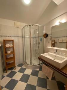 y baño con ducha y lavamanos. en Apart-Pension Wesenauerhof en Fuschl am See