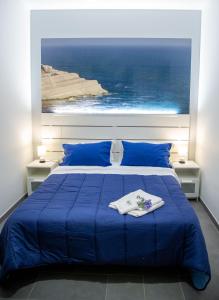 a bedroom with a blue bed with a view of the ocean at Brio Bed & Breakfast in Agrigento