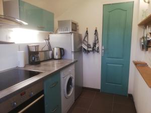 a kitchen with a refrigerator and a washing machine at Maison Normande proche de la mer et des commodités in Quettehou