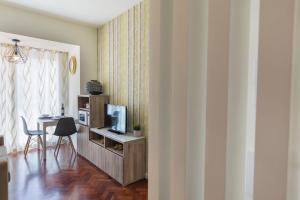 a room with a desk with a television and a table at Bairrus Lisbon Apartments - Duque in Lisbon