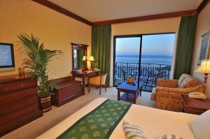 a hotel room with a bed and a view of the ocean at Grand Hotel Gozo in Għajnsielem