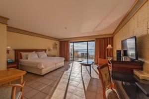 a bedroom with a bed and a desk and a television at Grand Hotel Gozo in Għajnsielem