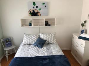 Un dormitorio con una cama con una almohada azul. en Le Chalet de Claude, au pied des Monts-Valin, en Saint-David-de-Falardeau