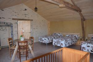a room with two beds and a table and chairs at A la Haute Bouillere in Chavagnes-les-Redoux