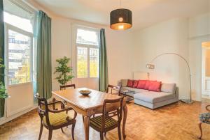 een woonkamer met een tafel, stoelen en een bank bij The National Lodge in Antwerpen