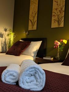 a bedroom with two towels on a bed at Crown Meadow - 4 Bedroom House - Heathrow - ExcellentStays in Colnbrook +24 photos