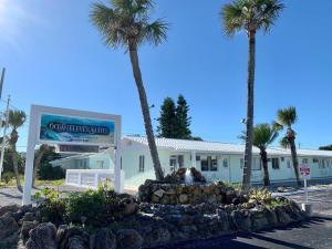 ein Gebäude mit Palmen davor in der Unterkunft Ocean Eleven Suites in New Smyrna Beach