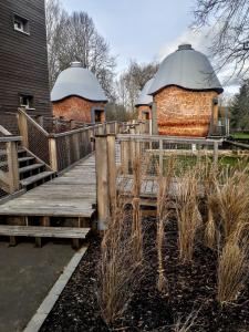 a wooden walkway leading to two buildings with domes at P&eacute;itche Lauer in Useldange