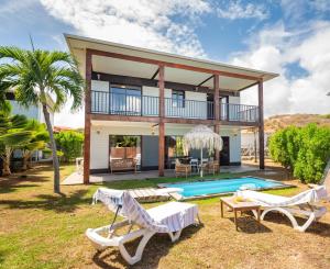 a villa with a pool and a house at Le Village de la Pointe in Le Vauclin