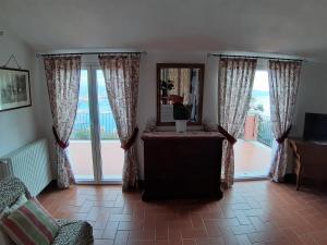 ein Wohnzimmer mit einem Tisch und großen Fenstern in der Unterkunft Villa Bellosguardo Apartments in La Spezia