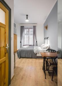 1 dormitorio con cama, mesa y escritorio en Pokoje Gościnne Św. Anny, en Cracovia