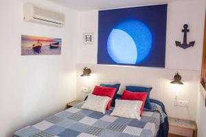 a bedroom with a bed with red and blue pillows at Apartment Oscar in Sitges