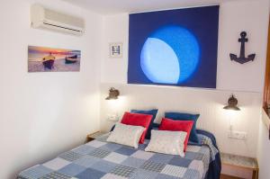 1 dormitorio con 1 cama con almohadas rojas y azules en Apartment Oscar, en Sitges