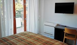 a bedroom with a bed and a desk and a television at Casa Dora in Cesena