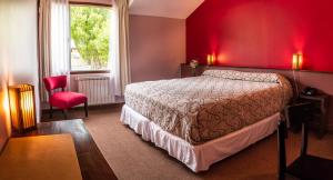 ein Schlafzimmer mit einem Bett und einer roten Wand in der Unterkunft Pudu Lodge in El Chalten