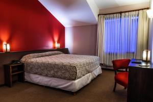 a hotel room with a bed and a red wall at Pudu Lodge in El Chalten