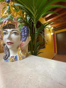 una estatua de una mujer con uvas en la cabeza en B&B L'Infiorescenza new, en Siracusa