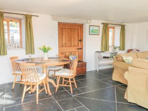 a living room with a table and chairs and a couch at The Byre in Kentisbury