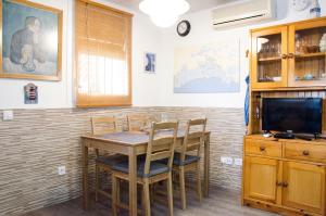 a dining room with a table and chairs and a tv at Apartment Oscar in Sitges