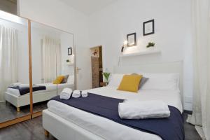 una camera da letto con un grande letto bianco e uno specchio di Urbana Delicious Flat a Roma