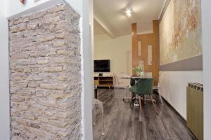 un soggiorno a pianta aperta con un muro in pietra e un tavolo di Urbana Delicious Flat a Roma