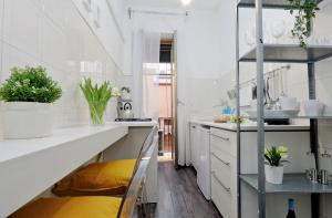 una cucina con ripiani bianchi e panca gialla di Urbana Delicious Flat a Roma Altre 26 foto