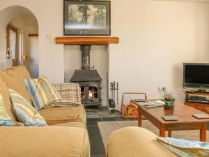 a living room with a couch and a fireplace at The Byre in Kentisbury