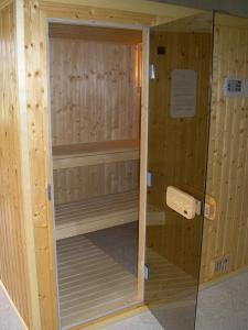 una pequeña sauna de madera con puerta de cristal en Au lézard doré, en Lamonzie-Montastruc