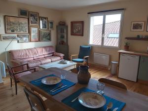 a living room with a table and a couch at Brocante Heaven 2 in Aignan +6 photos