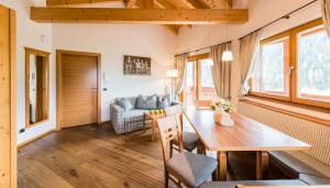 uma sala de estar com uma mesa e um sofá em Residence Sovara em Santa Cristina in Val Gardena