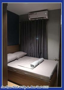 a bedroom with a bed with a air conditioner on it at San Remo Oasis at City de Mare U4332 in Cebu City