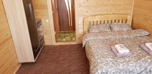 a bedroom with a bed in a wooden room at Marichka in Yablunytsya