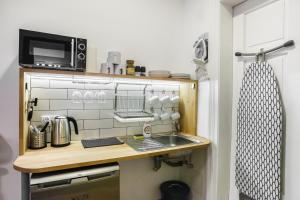 a small kitchen with a sink and a microwave at Pokoje Gościnne Św. Anny in Krakow