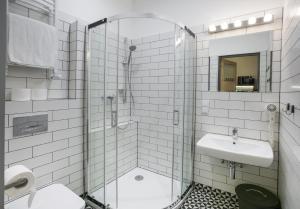 a bathroom with a glass shower and a sink at Pokoje Gościnne Św. Anny in Krakow
